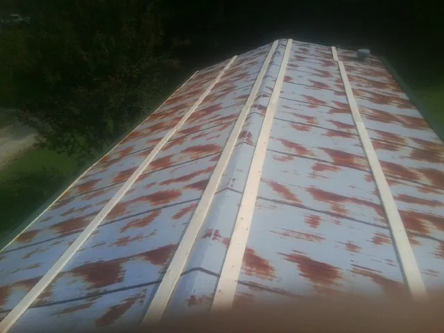 Rusted metal roof panels with new wood purlins before replacement — Storm Damage Roof Repair in Wilmette by Roofing Brothers