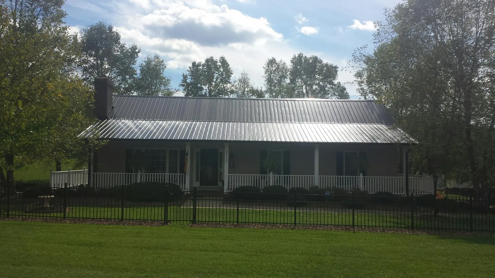 Gray metal roof on a brick ranch with a full width front porch — Gutter Guard Installation work by our crew in Wilmette