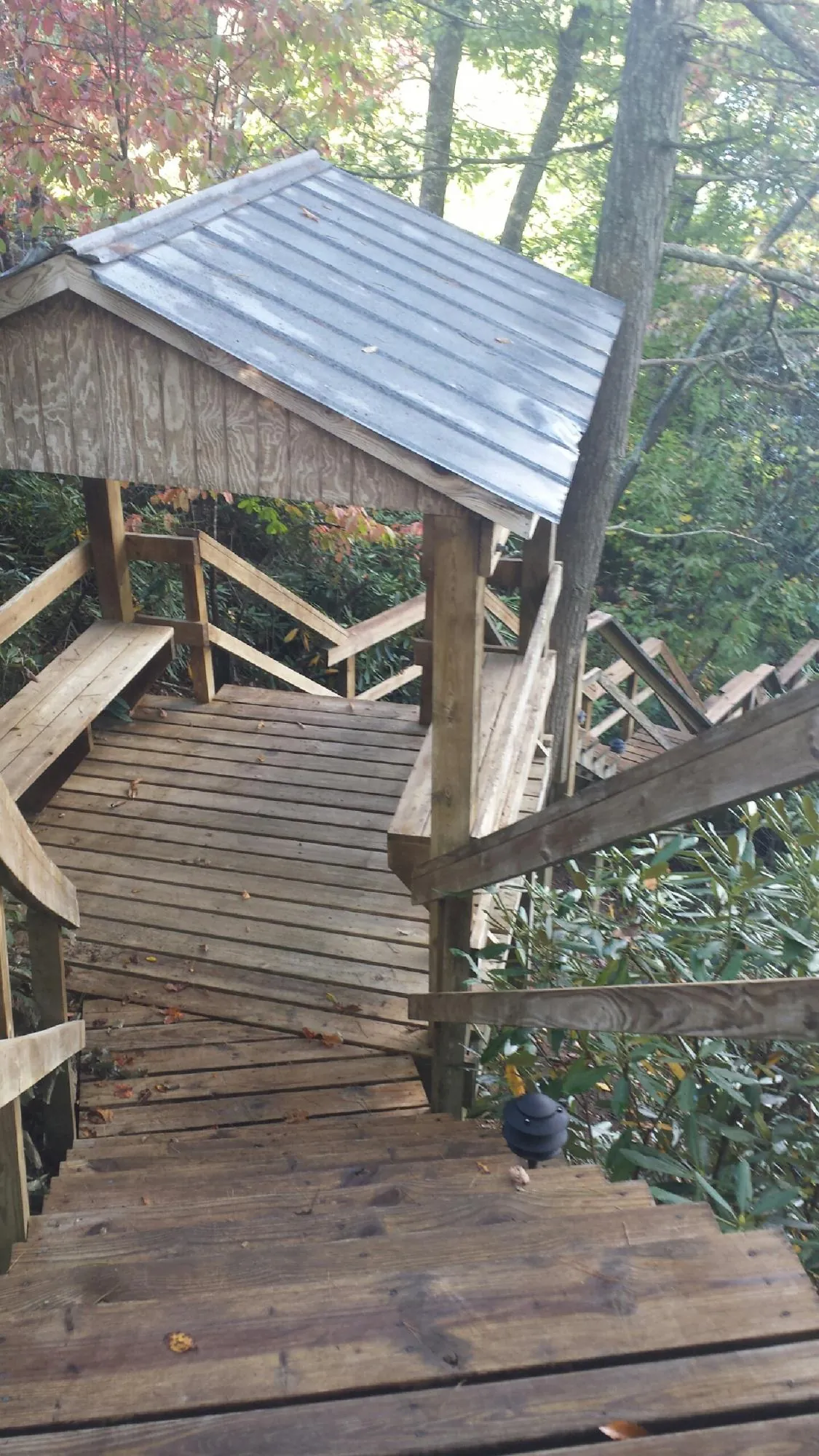 Metal roofed shelter over wooden steps on a wooded walkway — Skylight Repair & Installation work by our crew in Wilmette